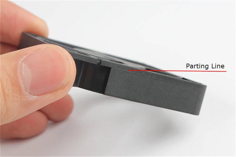 Injection molded plastic part design guidelines showing a visible parting line on a finished molded component